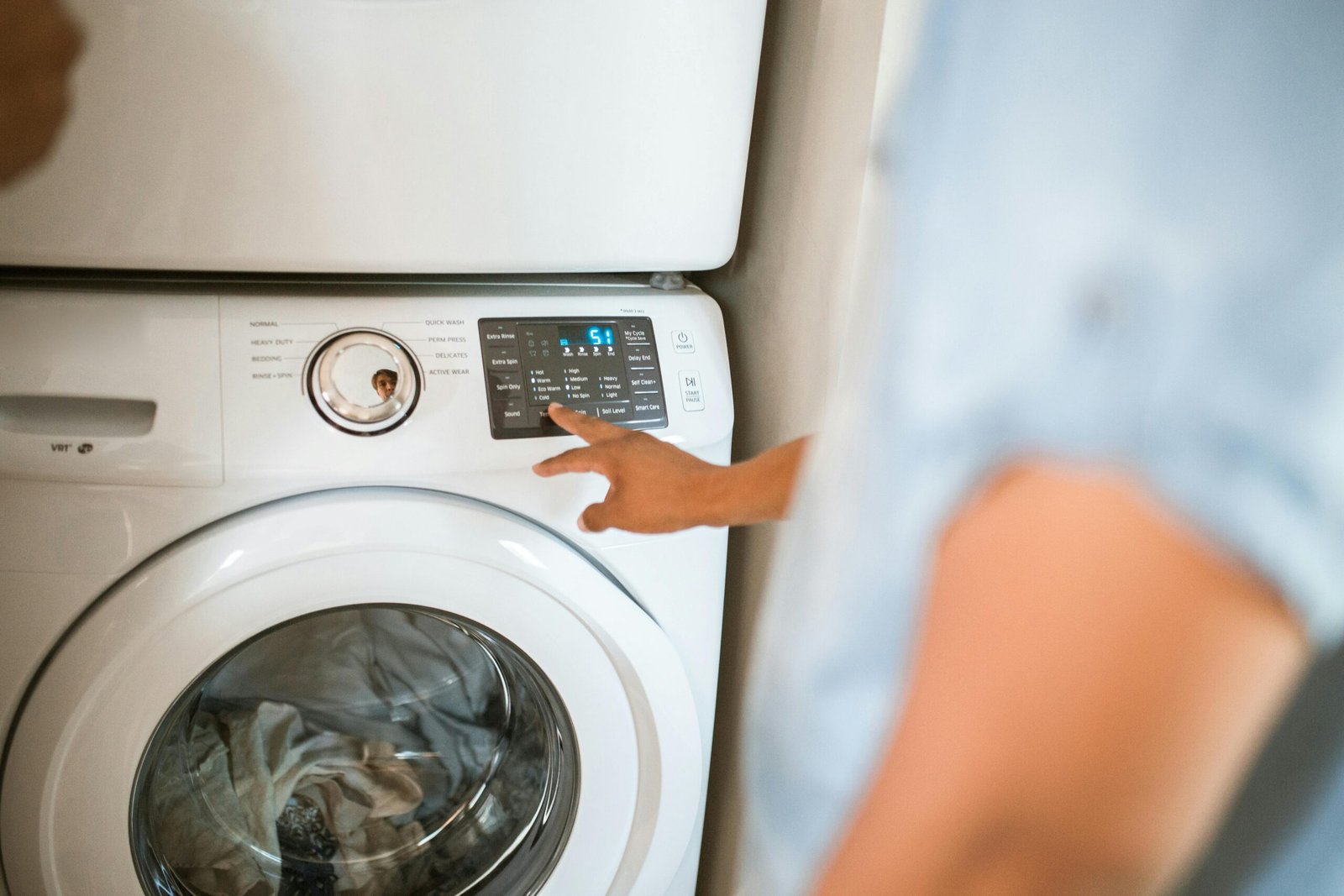 durham-install-pros Install technician in Durham, testing a washer and dryer to make sure that they were installed correctly.
